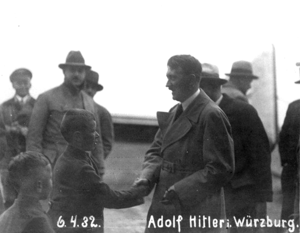 Adolf Hitler greets some young boys at his arrival in Würzburg where he gave a speech in Frankenhalle in front of 4,000 participants
